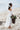 Young girl wearing ivory flower girl dress holding floral basket - beach wedding inspiration