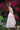 Woman in a pink dress standing in front of pink flowers