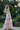 Tea Princess blush pink set for tween girls with ruffle detailing and standing in garden- back shot facing camera