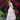 Teen girl wearing blush bloom pink two piece top and tiered maxi skirt with ruffle detaling standing in garden with flowers