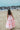 Tween girl wearing blush bloom pink two piece top and maxi skirt with ruffle detaling standing on the beach